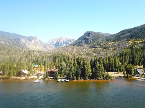 Grand Lake from the air — docks and lakefront homes beneath forested slopes